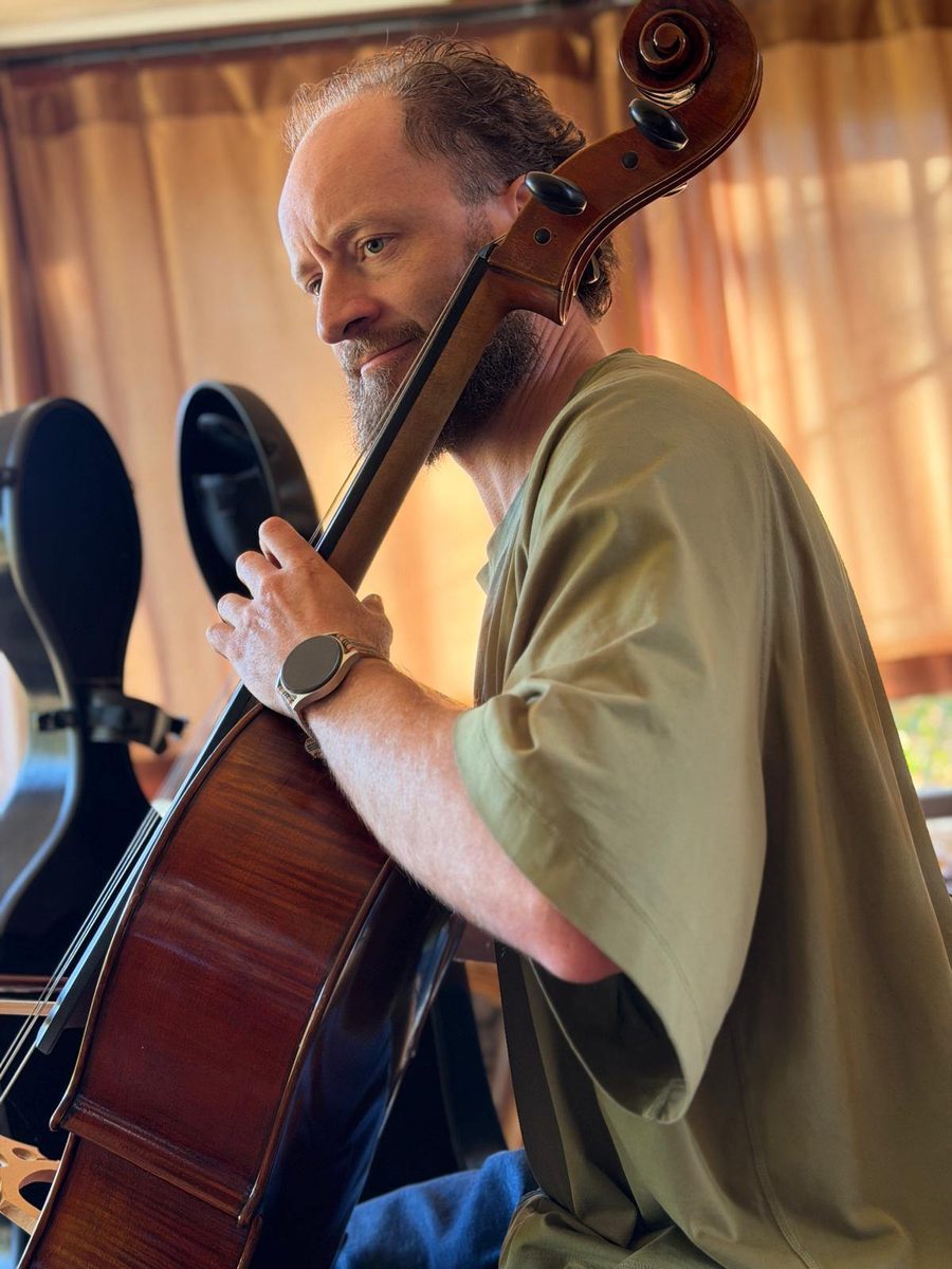 Courage seated with his cello, looking back over the scroll